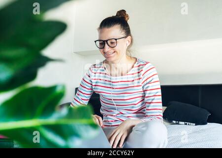 giovane tutor donna in cuffia con videochiamata che lavora su laptop a casa a distanza. formazione online a distanza in quarantena auto isolamento. studente tal Foto Stock