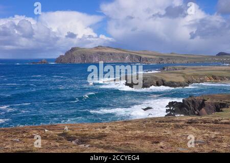 Vista da Clogher dirigiti verso Sybil Head sul sentiero costiero con un oceano Atlantico agile che colpisce le rocce. Una giornata primaverile con un interessante c Foto Stock