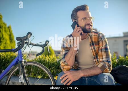 Uomo sorridente calmo con smartphone vicino all'orecchio Foto Stock