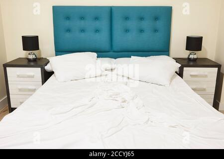 Camera con letto matrimoniale non fatto. Indoor nessuno. Orizzontale Foto Stock