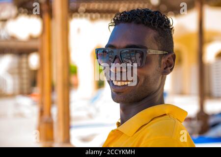 Egitto, Hurghada - ritratto sorridente del personale egiziano del bagnino dell'hotel nell'area della piscina sullo sfondo Foto Stock