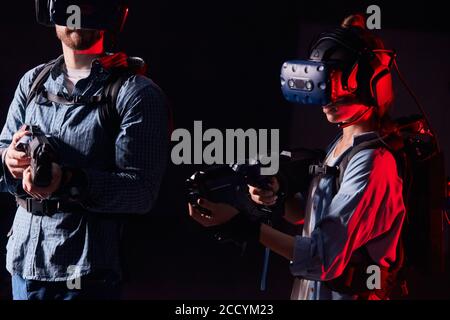 due giovani uomini e donne combattono con qualcuno in virtuale cuffie che indossano la realtà Foto Stock
