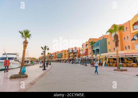 Egitto, porto della baia di Hurghada Marina con edifici colorati lungo la strada estiva del tramonto Foto Stock