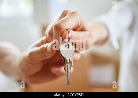 Le mani di coppia tengono le chiavi alla nuova casa dopo il movimento Foto Stock