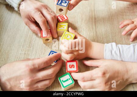 I bambini e gli anziani giocano con blocchi colorati per imparare o terapia Foto Stock