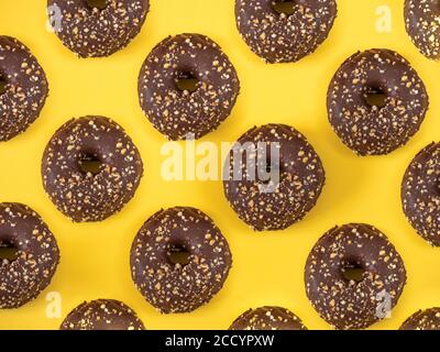 Ciambelle di cioccolato con motivo di mandorla su sfondo giallo Foto Stock