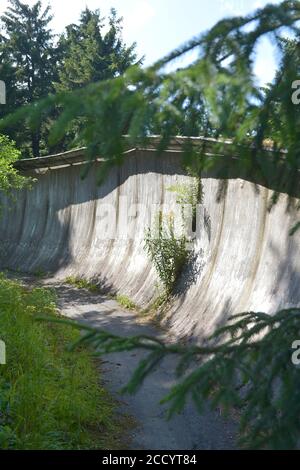 20 luglio 2020, Sassonia, Fichtelberg: L'ex pista luge del club sportivo della GDR Traktor Oberwiesenthal a Fichtelberg, nell'Erzgebirge, viene lentamente rilevata dalla natura. Alla fine degli anni '60, la pista da slitta da corsa lunga 1100 m, lunga 1100 m, che ama la natura, composta da elementi prefabbricati in calcestruzzo, fu costruita sul versante nord-orientale. Dopo la svolta politica ha perso la sua importanza, l'operazione è stata interrotta e la pista è stata parzialmente smantellata. Foto: Volkmar Heinz/dpa-Zentralbild/ZB Foto Stock