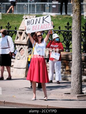 Ottawa, Canada. Donna con il cartello 'Hunk for Belarus' sul lato della strada durante il supporto marzo il giorno del nastro nero Foto Stock