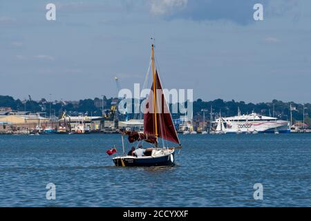 Shrimper vela nel porto di Poole vicino al terminal dei traghetti Foto Stock