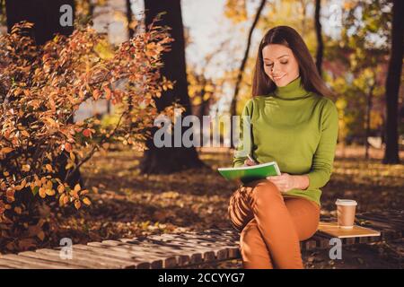 Foto di bella signora affascinante venire autunno parco sulla strada casa tenere penna copybook siedono panca bere caffè correggendo i compiti gli errori lasciano cadere l'usura Foto Stock