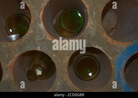 Un primo piano di un titolare di vino pesante con un poche bottiglie che vengono conservate all'interno Foto Stock