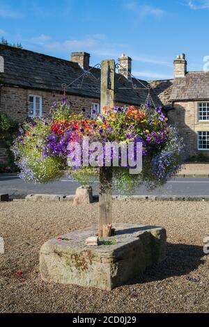 Cestini appesi e mostra floreale nel villaggio di Blanchland Northumberland Foto Stock