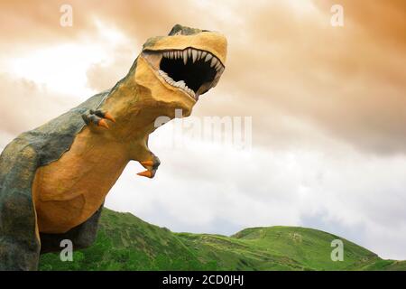 Statua di dinosauro in un campo Foto Stock