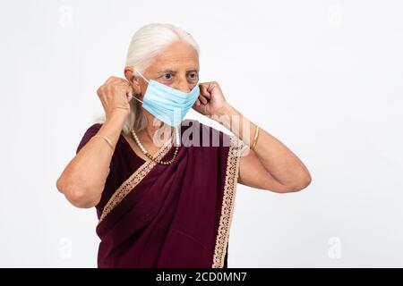 Donna indiana matura che indossa maschera di protezione Covid-19, donna indiana anziana che indossa maschera facciale Foto Stock
