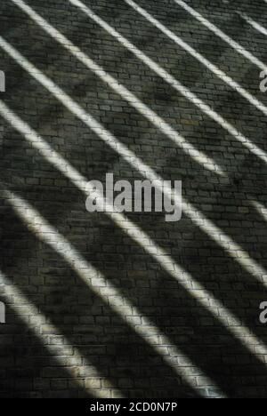 Immagine di strisce diagonali bianche sulla parete di mattoni neri sfondo Foto Stock