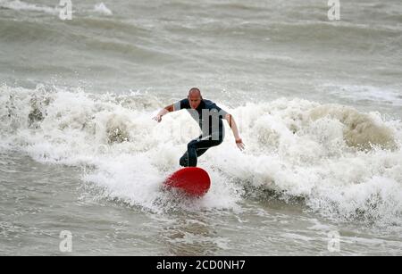 Un surfista ama i mari ruvidi di Eastbourne, East Sussex, mentre i venti fino a 70 mph sono attesi lungo la costa durante le prossime 36 ore insieme a fino a 90 mm di pioggia, quando Storm Francis ha colpito il Regno Unito. Foto Stock