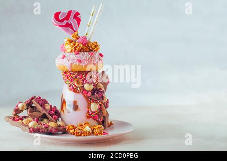 Raspberry Freak agita con ciambella, popcorn e dolci su sfondo grigio con spazio di copia; fuoco selettivo. Foto Stock