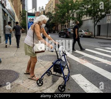 La donna anziana attraversa un pericoloso incrocio di Eighth Avenue a Chelsea a New York martedì 11 agosto 2020. (© Richard B. Levine) Foto Stock