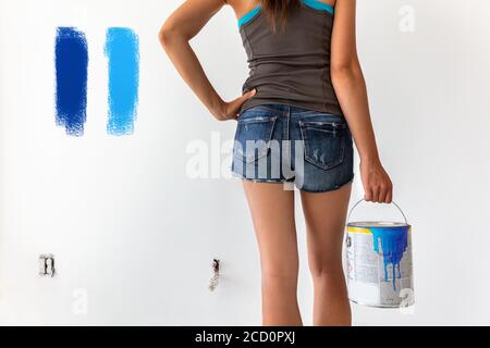 Campioni di colori di vernice - pareti di pittura di donna durante la ristrutturazione domestica. Tendenze cromatiche per il design degli interni per la parete della casa Foto Stock