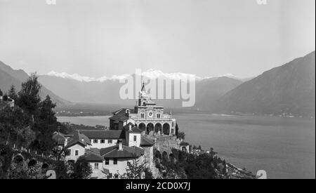 Una fotografia in bianco e nero degli anni '20 che mostra il santuario della Madonna del Sasso e la chiesa pellegrina sopra la città di Locarno in Svizzera. Foto Stock