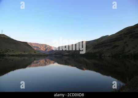 luna che sale al crepuscolo sopra la diga di ossbow in idaho Foto Stock