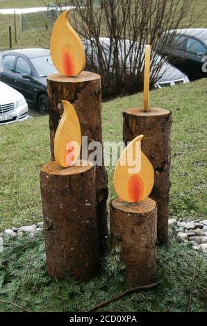 Quattro candele di legno di diverse altezze. Organizzato come una corona di avvento. Foto Stock