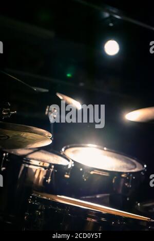 Immagine di un drumkit per l'esportazione di perle in una stanza buia, illuminata da un riflettore Foto Stock