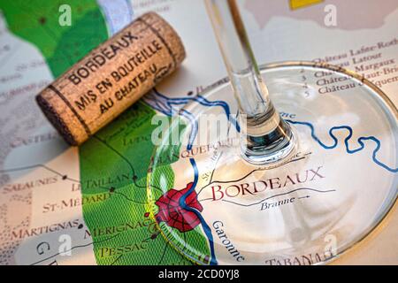 Bordeaux Mappa Tour del vino francese concetto di degustazione, gambo di vino in vetro, Bordeaux Chateau tappo d'annata in primo piano, sulla vecchia storica Bordeaux fine zone mappa delle zone di vino Bordeaux Francia Foto Stock