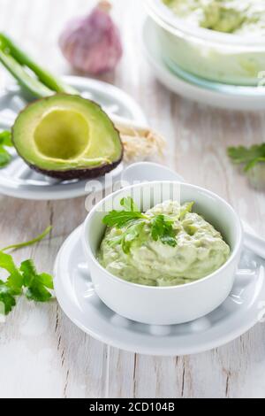 Delizioso avocado spalmato con formaggio di cagliata e ingredienti. Concetto di cibo heathy. Foto Stock