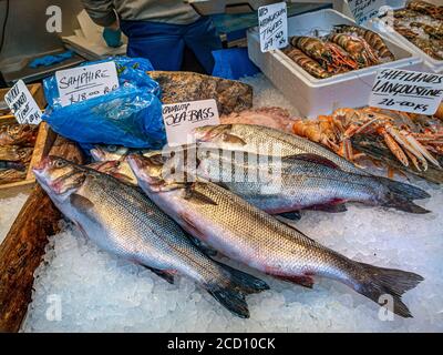 I pesci freschi britannici mostrano varietà di pesce tra cui Sea Bass, Samphire, Shetlands Langoustine, Trout, sullo stallo mercato dei pescatori, esposti in vendita al Borough Market Southwark London UK Foto Stock