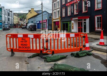 Bantry, West Cork, Irlanda. 25 Agosto 2020. La città di Bantry è stata vittima di grandi inondazioni la scorsa notte, con almeno 50 case e aziende che hanno subito danni significativi all'acqua e al fango. Le inondazioni si sono verificate durante un diluvio di 4 ore di pioggia. La forza dell'acqua ha strappato su parte della strada in New Street. Il Cork County Council è raffigurato facendo riparazioni di emergenza sulla strada. Credit: AG News/Alamy Live News Foto Stock