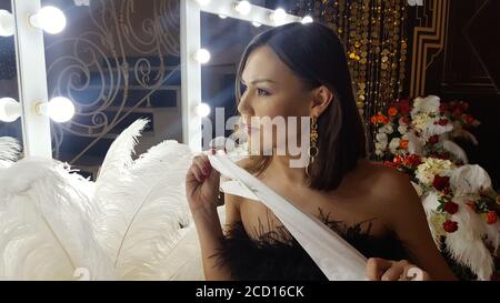 Piume decorative di struzzo su un tavolo d'oro accanto ad uno specchio per  il trucco Foto stock - Alamy