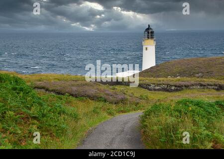 Faro di Rua Reidh sulla penisola di Gairloch, Highlands scozzesi, Regno Unito, con percorso che conduce attraverso l'erba e erica al faro. Cielo tempestoso. Foto Stock