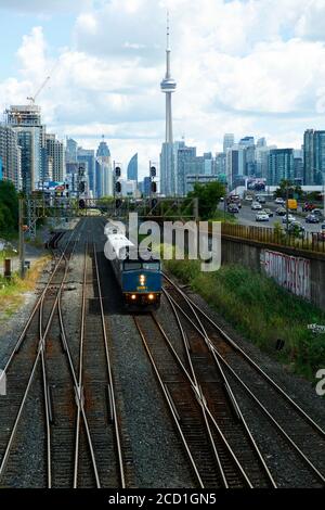 Vista della CN Tower, degli appartamenti e del treno Via che parte dal centro di Toronto, Ontario, Canada Foto Stock