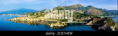 Vista panoramica aerea della città di Taormina, della riserva naturale dell'isola Bella e dell'Etna sulla costa orientale della Sicilia Foto Stock