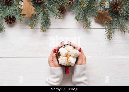 Caffè di Natale in mano e cornice festiva decorativa di abete verde, giocattolo di legno. Foto Stock