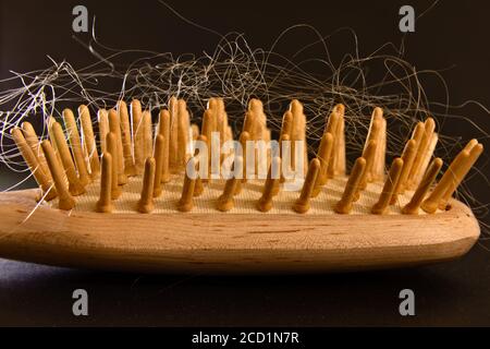 Spazzola in legno con peli biondi, fondo nero Foto Stock