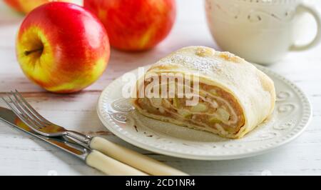 Strudel con mela e cannella. Tradizionale torta fatta in casa a strati con ripieno di frutta, servita con zucchero in polvere. Delizioso dessert. Messa a fuoco selettiva Foto Stock