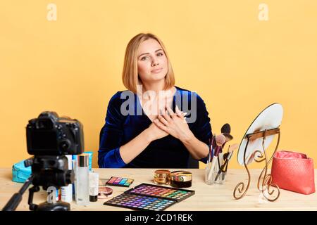 Vista isolata di felice popolare blogger ragazza con capelli biondi piega le mani sul petto, esprime gratitudine, si sente grato per le parole gentili verso il suo essere Foto Stock