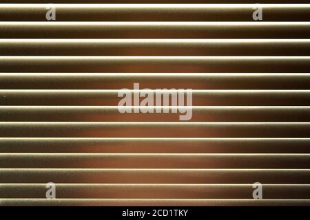 Dettaglio su persiane metalliche, qualche luce si riflette su, polvere visibile, astratto sfondo geometrico Foto Stock