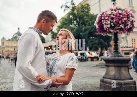 Coppia amorosa che cammina nella vecchia città di Lviv indossando camicie tradizionali ucraine nazionali. Gli sposi novelli trascorrono il tempo insieme Foto Stock