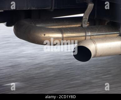 Scarico di un carrello in movimento con asfalto della strada sfocato in movimento, vista ravvicinata. Foto Stock