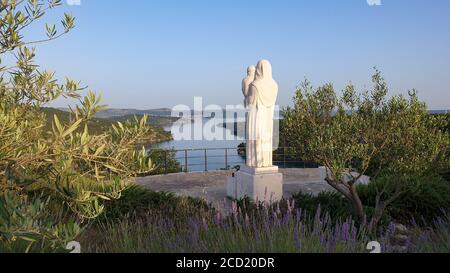 Bellissimo scatto dell'estuario del fiume Krka dal ponte Skradin - Krka e una statua di Maria, Foto Stock