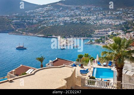 Charter barche di ritorno al porto di Kalkan visto dalle ville a Kormuluk. Kalkan, Provincia di Antalya, Costa Mediterranea, Antica Regione di Lycia, Turchia Foto Stock