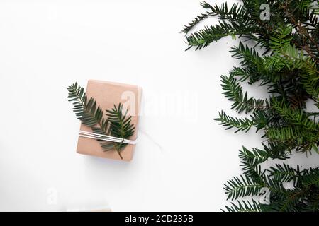 Facile regalo di carta marrone con albero di Natale su tavolo bianco Foto Stock
