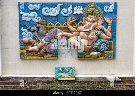 Le piastrelle con Ganesha sdraiato su un muro nel parco tempio di Ganesha provincia di Nakhon Nayok, Thailandia. Foto Stock