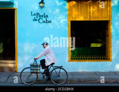 CAMAGUEY, CUBA - CIRCA GENNAIO 2020: Uomo in bicicletta per le strade di Camaguey Foto Stock
