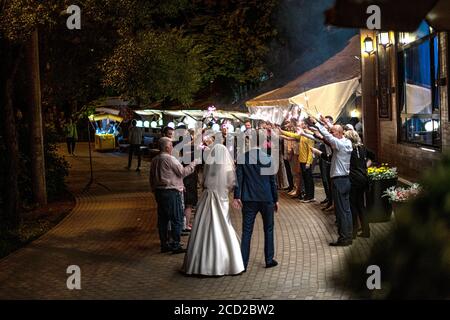 Gli ospiti gettando coriandoli sopra la sposa e lo sposo a Wedding Foto Stock