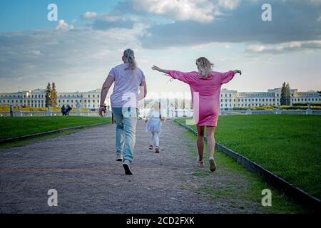 Una famiglia che corre insieme in un parco Foto Stock