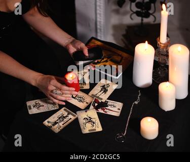 Scuro piatto di oggetti streghy. Carte Tarocchi sparse. Previsione wicca, occulto, esoterico, divinazione e concetto di misctico. Rituali magici. Foto Stock